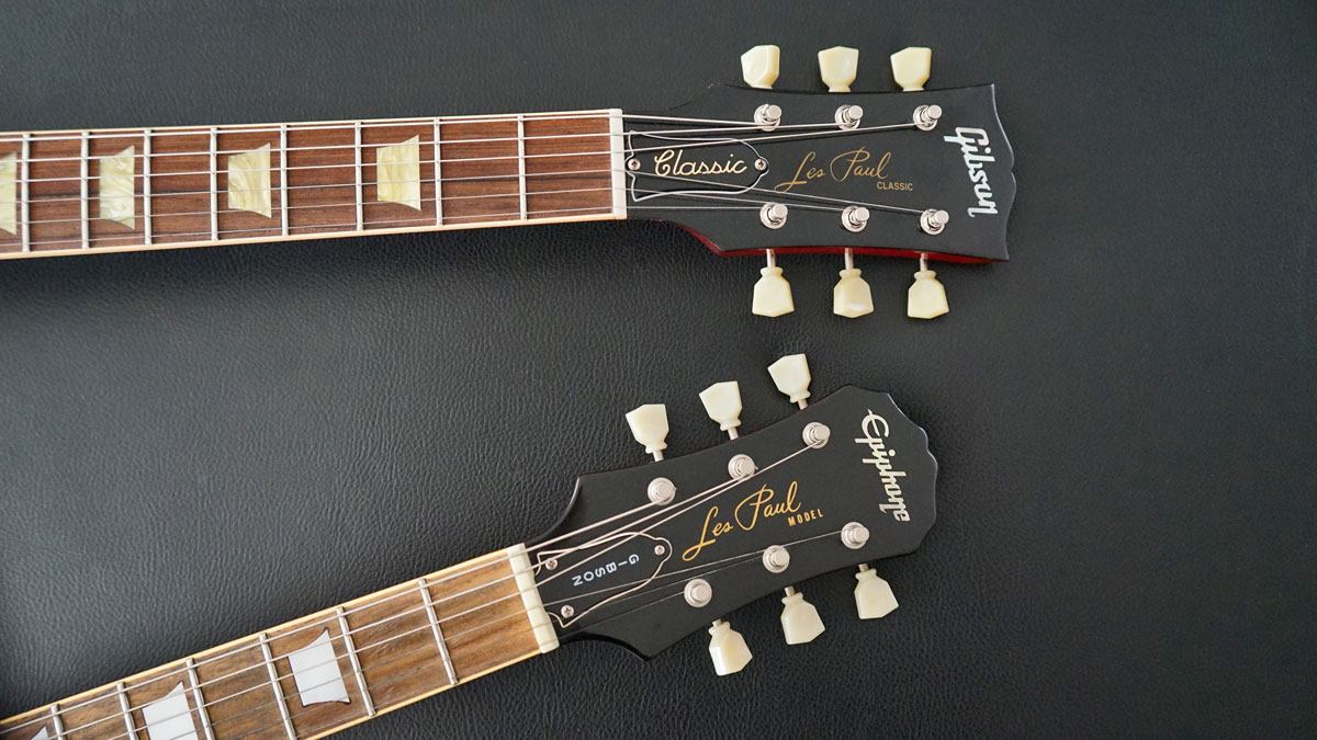 Die charakteristischen Kopfplatten einer Gibson und einer Epiphone Les Paul